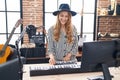 Young blonde woman musician playing piano keyboard at music studio Royalty Free Stock Photo