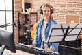 Young blonde woman musician playing piano keyboard at music studio Royalty Free Stock Photo