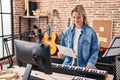 Young blonde woman musician playing piano keyboard at music studio Royalty Free Stock Photo