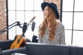 Young blonde woman musician singing song playing piano keyboard at music studio Royalty Free Stock Photo