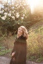 Young blonde woman near blossoming magnolia flowers tree in spring park on sunny day. Magnolia trees. Beautiful happy Royalty Free Stock Photo