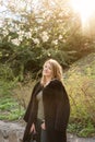 Young blonde woman near blossoming magnolia flowers tree in spring park on sunny day. Magnolia trees. Beautiful happy Royalty Free Stock Photo