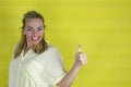 Young blonde woman over isolated background smiling with happy face looking and pointing with thump up