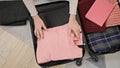 Young blonde woman packing clothes on suitcase for journey at home Royalty Free Stock Photo