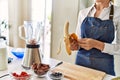 Young blonde woman peeling banana at kitchen Royalty Free Stock Photo