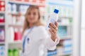 Young blonde woman pharmacist smiling confident holding medication bottle at pharmacy Royalty Free Stock Photo