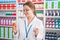 Young blonde woman pharmacist smiling confident holding two pills bottles at pharmacy Royalty Free Stock Photo