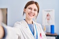 Young blonde woman physiotherapist smiling confident make selfie by camera at rehab clinic