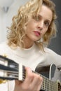Young blonde woman playing the acoustic guitar Royalty Free Stock Photo