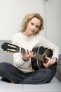Young blonde woman playing the acoustic guitar Royalty Free Stock Photo