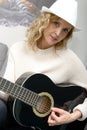 Young blonde woman playing the acoustic guitar Royalty Free Stock Photo