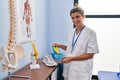 Young blonde woman podiatrist holding insole at clinic