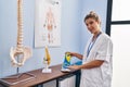 Young blonde woman podiatrist holding insole at clinic