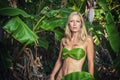 Young blonde woman posing with banana leaves Royalty Free Stock Photo