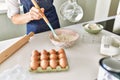 Young blonde woman pouring water on bowl at kitchen Royalty Free Stock Photo