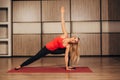 Young blonde woman practicing yoga,-Virabhadrasana Rotated warrior pose