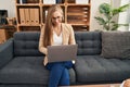 Young blonde woman psychologist using laptop at psychology clinic