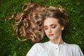 Young blonde woman relaxing on green grass outdoor Royalty Free Stock Photo