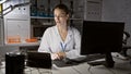 Young blonde woman researcher working in a laboratory with computer and microscope Royalty Free Stock Photo