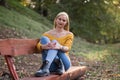 Young blonde woman resting on a bench in the forest Royalty Free Stock Photo