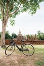 Young blonde woman riding a bicycle looking architecture in nature, in Sukhotai historical park