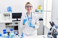 Young blonde woman scientist analysing test tubes at laboratory