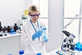 Young blonde woman scientist analysing test tubes at laboratory