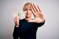 Young blonde woman with short hair holding one dollar banknote over isolated background with open hand doing stop sign with Royalty Free Stock Photo