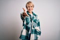 Young blonde woman with short hair wearing casual retro green shirt over isolated background smiling friendly offering handshake Royalty Free Stock Photo