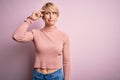 Young blonde woman with short hair wearing casual turtleneck sweater over pink background worried and stressed about a problem Royalty Free Stock Photo