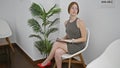 Young blonde woman sitting on chair looking around at waiting room Royalty Free Stock Photo