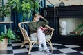 Young blonde woman sitting in comfortable chair reading a book Royalty Free Stock Photo