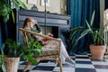 Young blonde woman sitting in comfortable chair reading a book Royalty Free Stock Photo