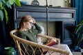 Young blonde woman sitting in comfortable chair reading a book Royalty Free Stock Photo