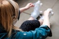 Young blonde woman sitting on the floor tying shoe laces on her roller skate Royalty Free Stock Photo