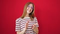 Young blonde woman smiling confident clapping applause over isolated red background