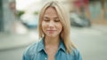 Young blonde woman smiling confident with close eyes at street Royalty Free Stock Photo