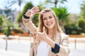 Young blonde woman smiling confident doing photo gesture with hands at park Royalty Free Stock Photo