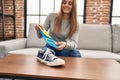 Young blonde woman smiling confident holding insole shoe at home
