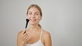 Young blonde woman smiling confident holding makeup brush over isolated white background Royalty Free Stock Photo