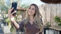 Young blonde woman smiling confident making selfie by the smartphone at coffee shop terrace Royalty Free Stock Photo