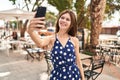 Young blonde woman smiling confident making selfie by the smartphone at coffee shop terrace Royalty Free Stock Photo