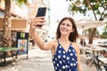 Young blonde woman smiling confident making selfie by the smartphone at coffee shop terrace Royalty Free Stock Photo