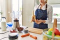 Young blonde woman smiling confident peeling banana at kitchen Royalty Free Stock Photo