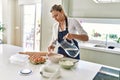 Young blonde woman smiling confident pouring water on bowl at kitchen Royalty Free Stock Photo