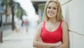 Young blonde woman smiling with crossed arms at street Royalty Free Stock Photo