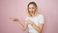 Young blonde woman smiling pointing to the side with fingers surprised over isolated pink background Royalty Free Stock Photo