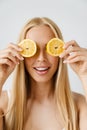 Young blonde woman smiling while posing with piece of lemon