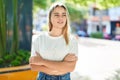 Young blonde woman standing with arms crossed gesture at park Royalty Free Stock Photo