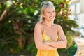 Young blonde woman standing with arms crossed gesture at park Royalty Free Stock Photo